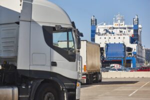Transportation and logistic industry. Trucks and vessel ready to be loaded in the harbor.